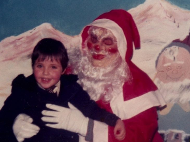 Santa Claus que da miedo cargando a un niño