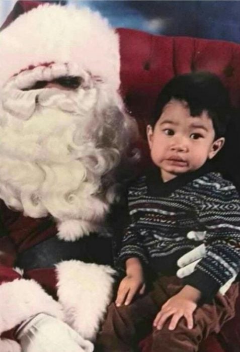 Santa Claus que da miedo cargando a un niño