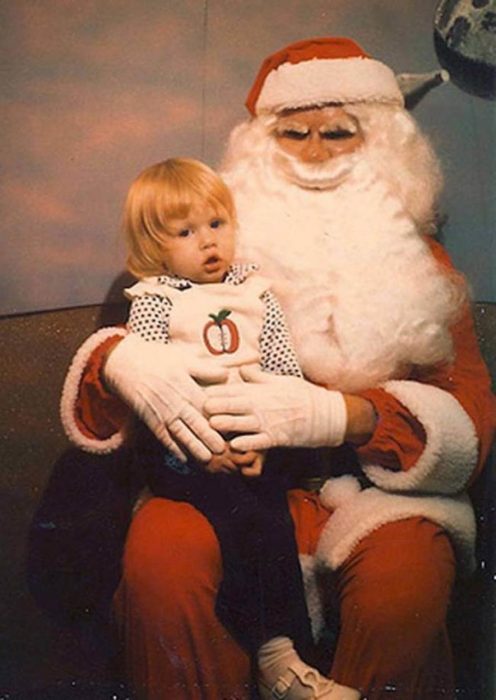 Santa Claus que da miedo cargando a un niño