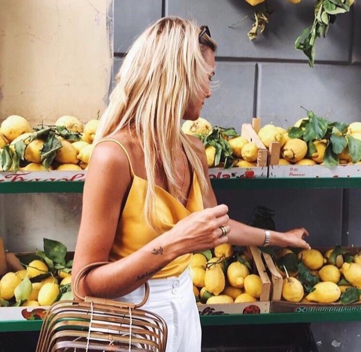 chica comprando limones en el supermercado