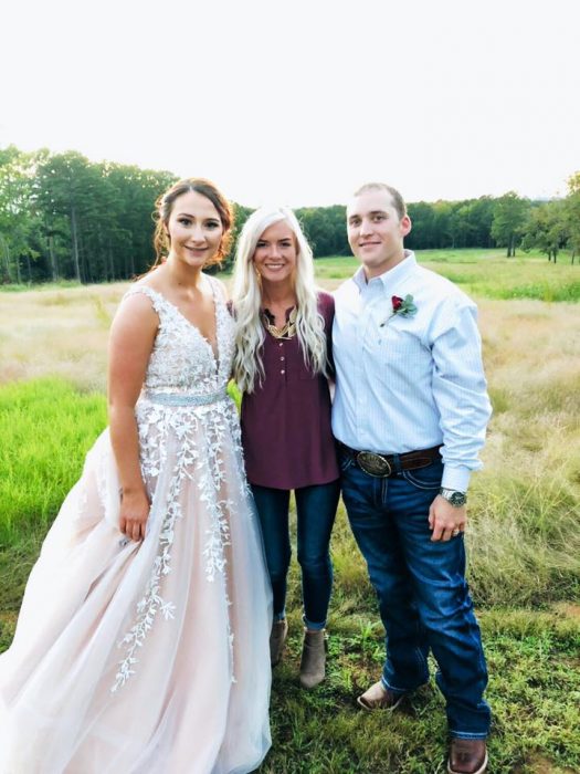 Chica que donó su boda a una pareja que la necesitaba posando junto a los novios