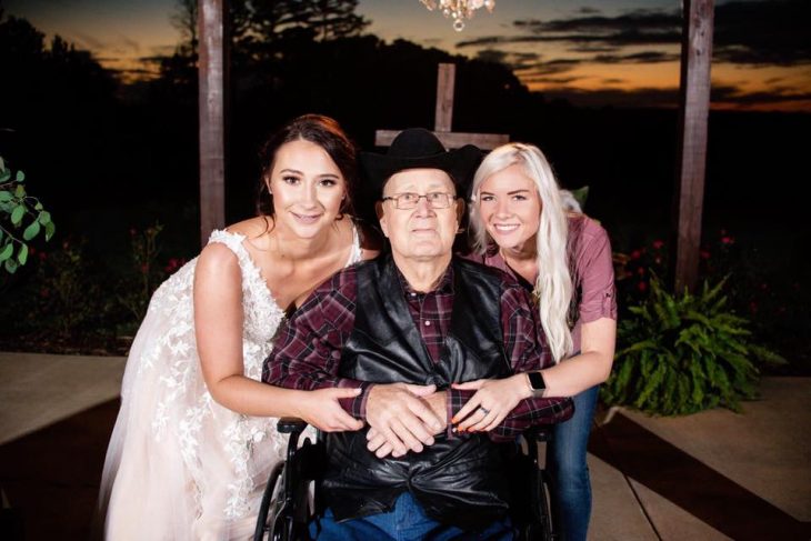 Novia posando junto a su abuelo y la chica que le regaló una boda 