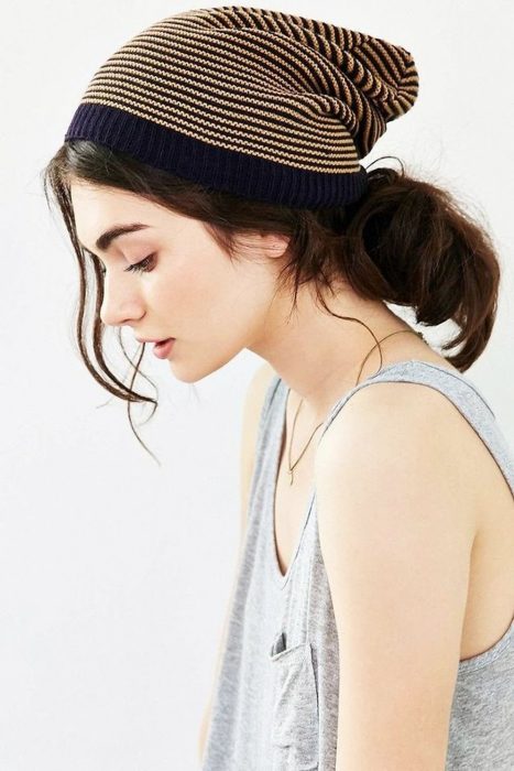 Chica de cabello castaño con una coleta utilizando un gorro de invierno