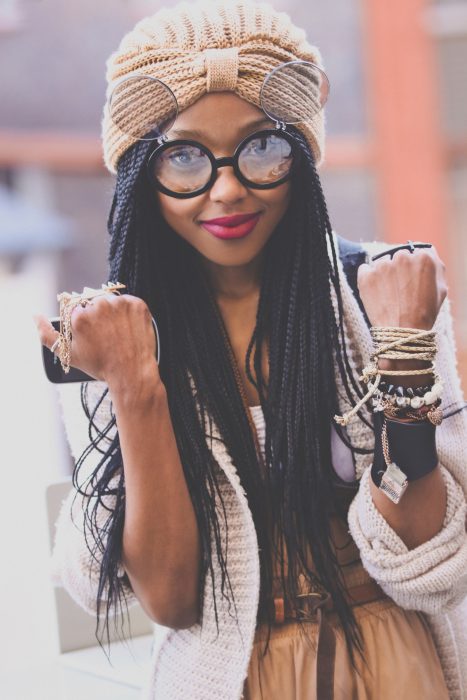 Chica de largas trenzas negras utilizando un gorro de invierno beige