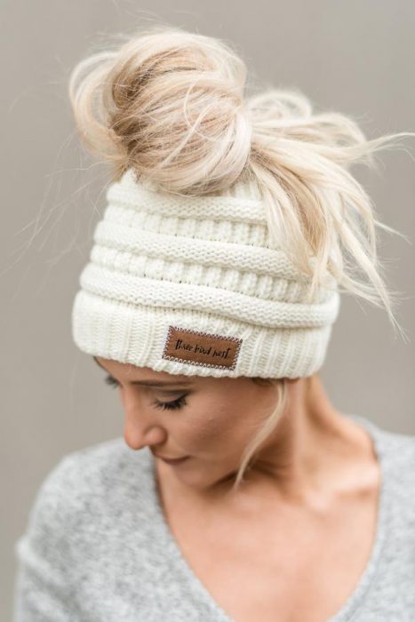 Chica rubia con gorro blanco para invierno y chongo