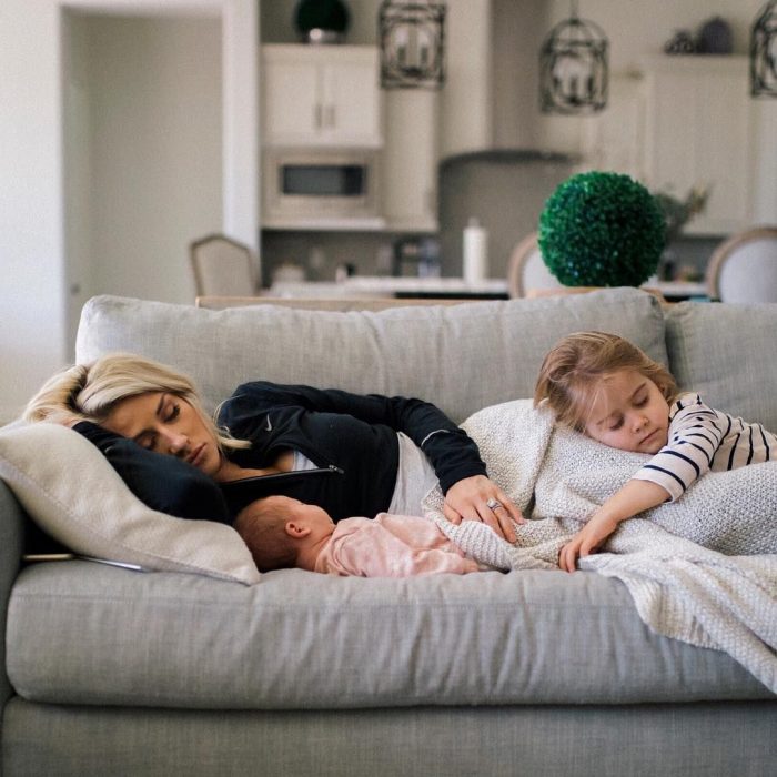 Mujer dormida en el sillón con sus dos hijos pequeños