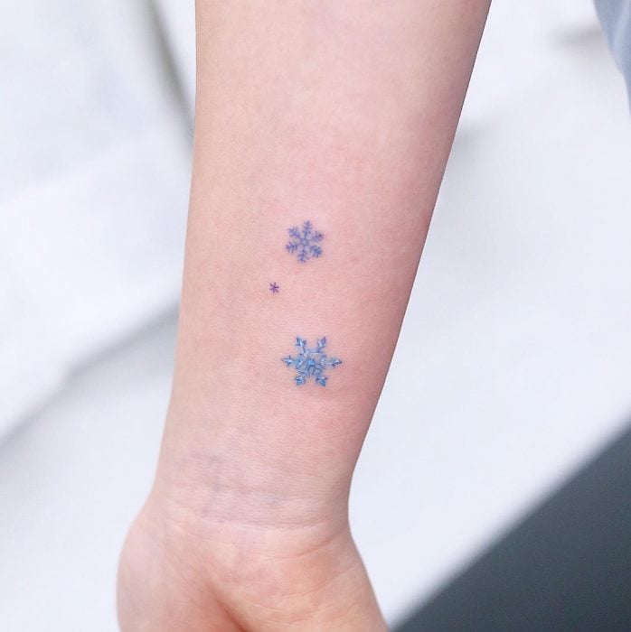 Chica con un tatuaje de copos de nieve 
