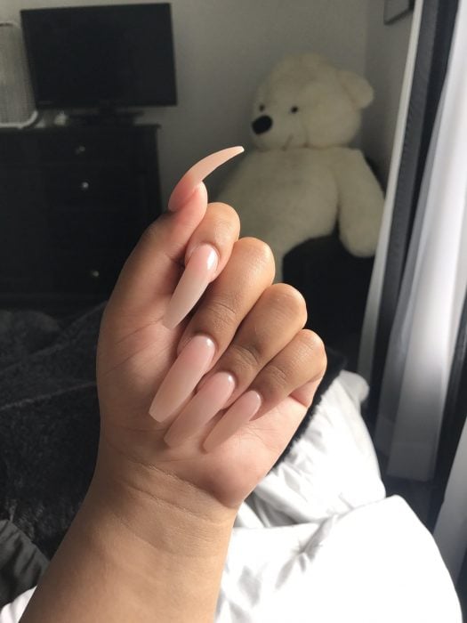 mujer con uñas largas de acrílico 