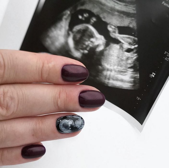 Mujer con unas uñas de ultrasonido pintadas en sus manos 