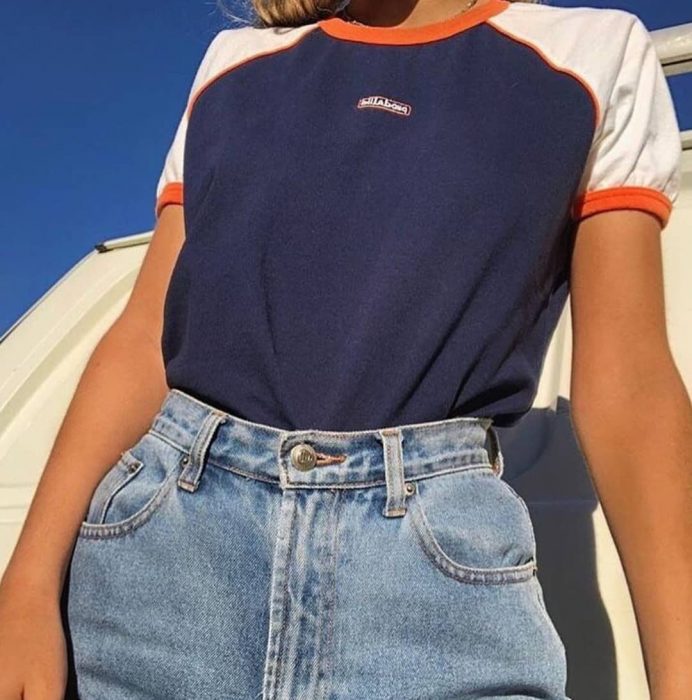 mujer con jeans a la cintura y playera azul 