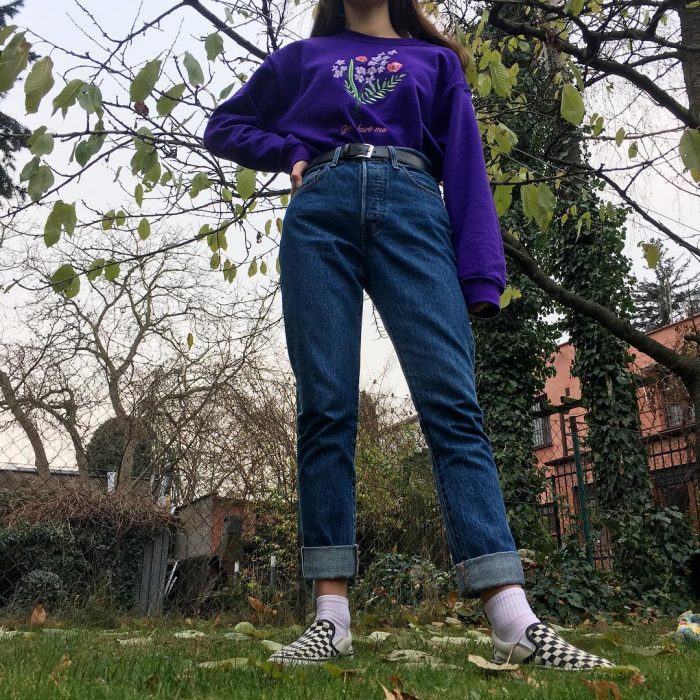 mujer con jeans de mezclilla y sudadera morada 