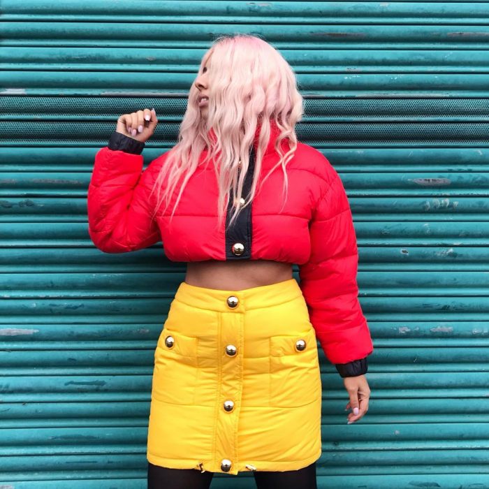 mujer con chamarra puffer crop top falda amarillo 