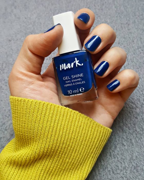 manos de mujer con uñas color azul 