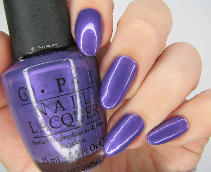 manos de mujer con uñas color morado