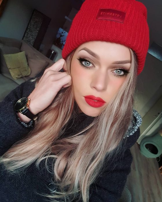 mujer con gorro rojo ojos azules y labios rojos 