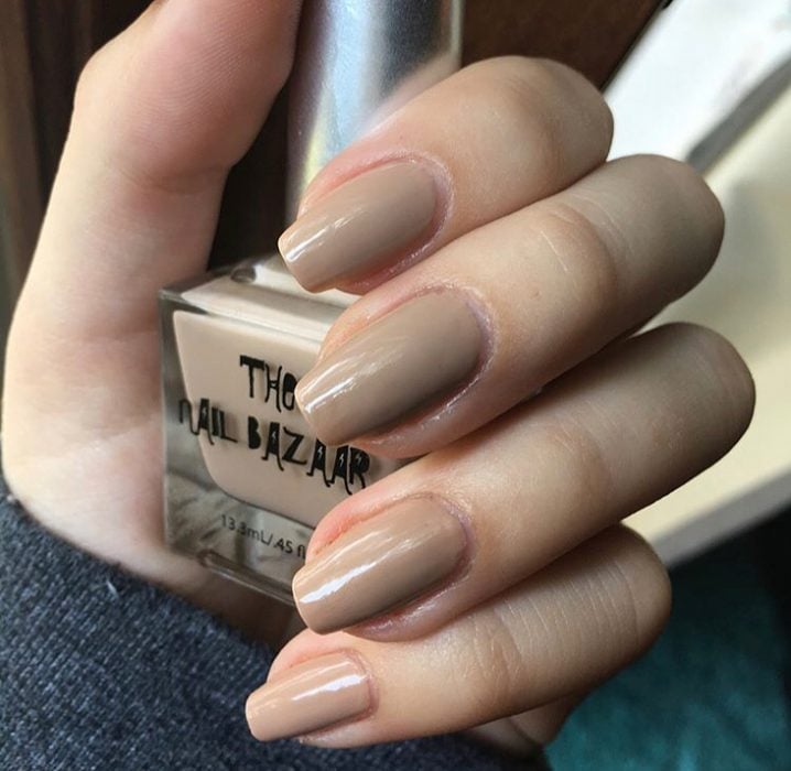 manos de mujer con uñas color nude 