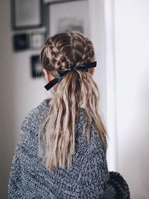 mujer con cabello rubio dos trenzas y coleta de caballo