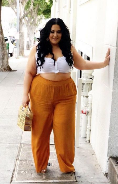 mujer con pantalón naranja de crop top blanco 