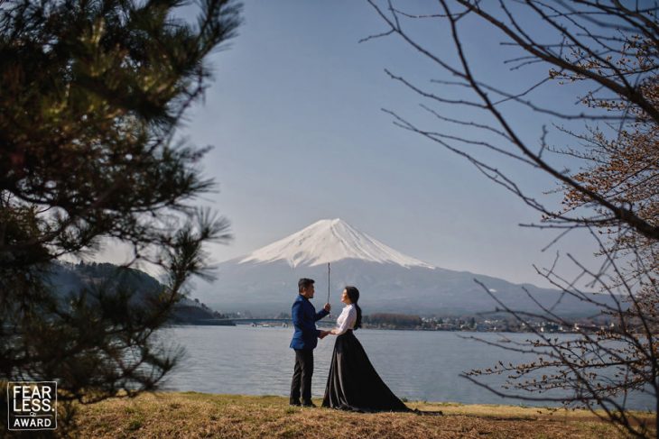 pareja en lago y montaña atrás