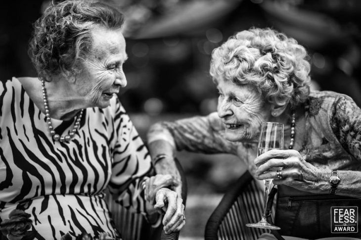 pareja de ancianas con copa sonriendo 