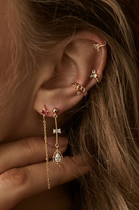 oreja de mujer con pearcings y aretes 