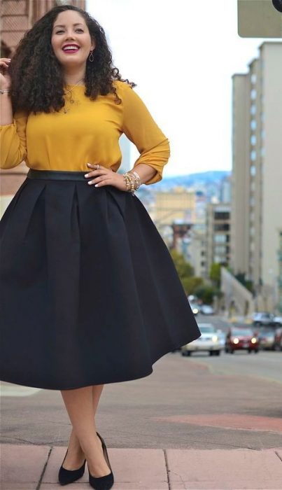 mujer con falda negra y camisa verde 