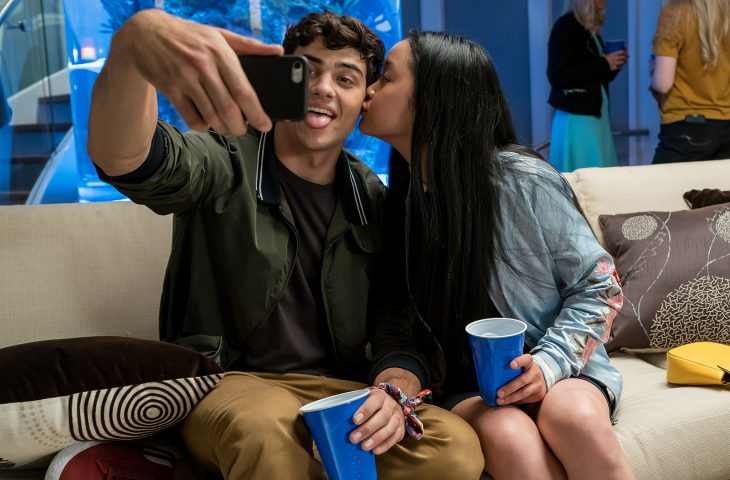 Pareja en una fiesta sentados en un sillón tomándose una selfie