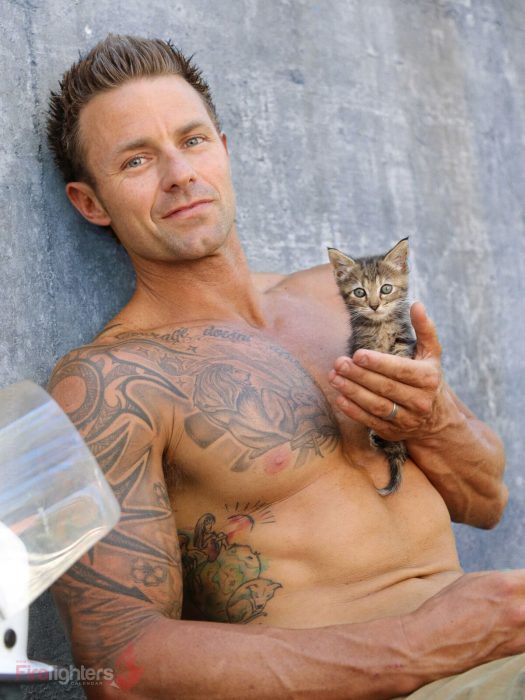 Bombero australiano posa para calendario en beneficencia de animales con gato con rayas