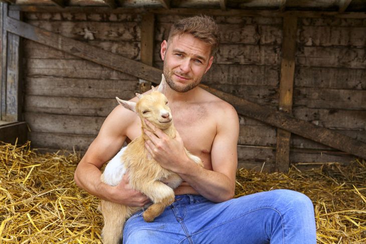 Hombre posando para un calendario irlandés 2019 junto animales de granja 