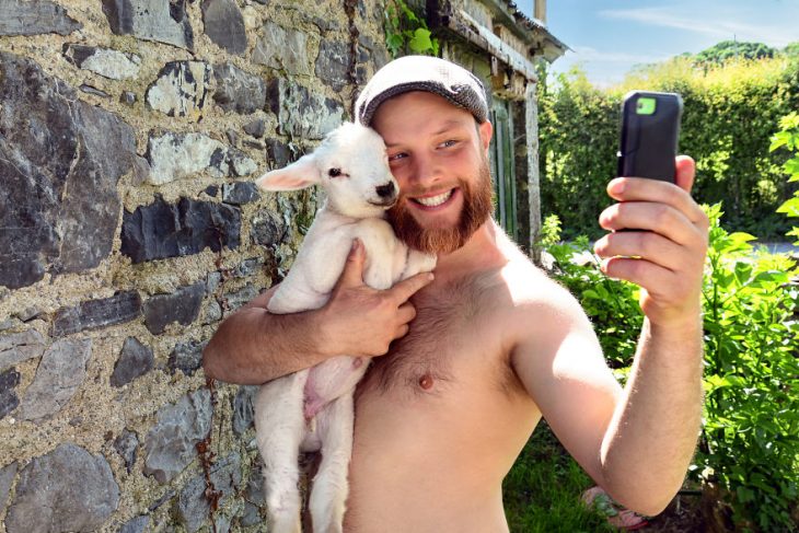 Hombre posando para un calendario irlandés 2019 junto animales de granja 