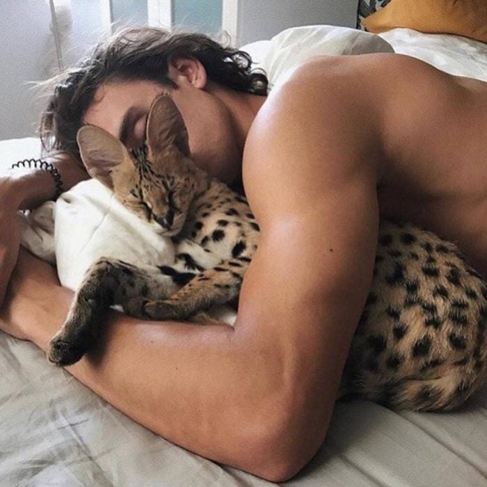 Chico ucraniano de cabello castaño dormido con un gato