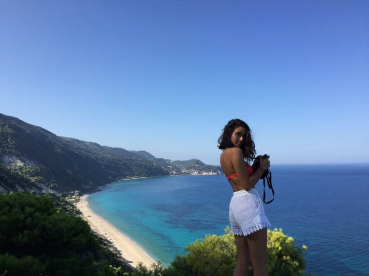 chica tomando fotos en una isla