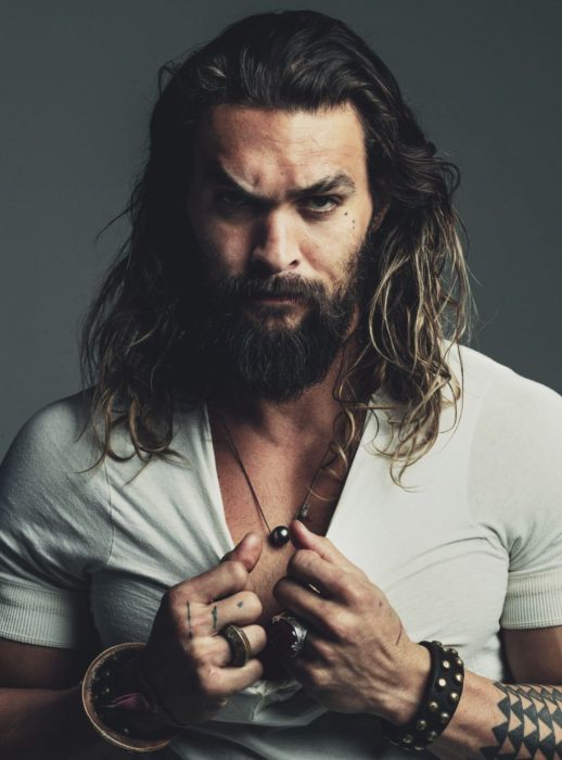 Jason Momoa, hombre de cabello largo con camisa blanca y mirada seria