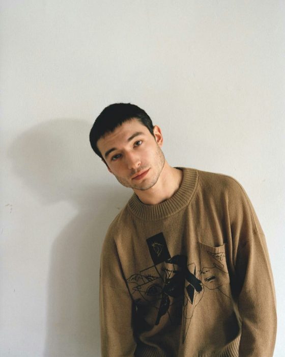 Ezra Miller, chico de cabello corto y sudadera café