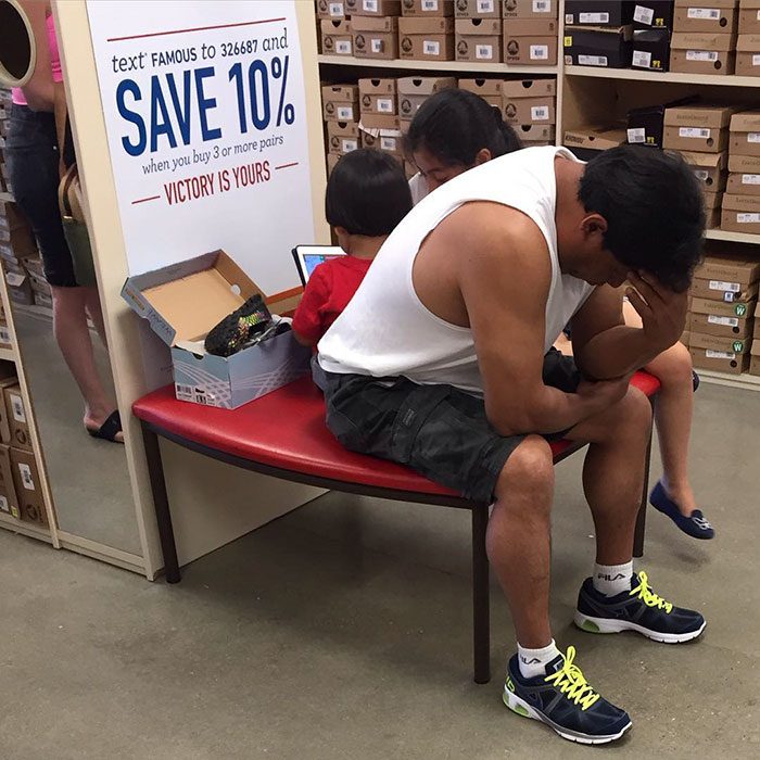 Hombres esperando que su mujer salda de las tiendas en el centro comercial 