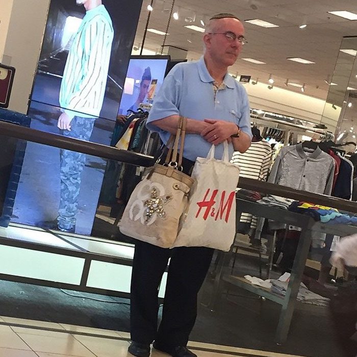 Hombres esperando que su mujer salda de las tiendas en el centro comercial 