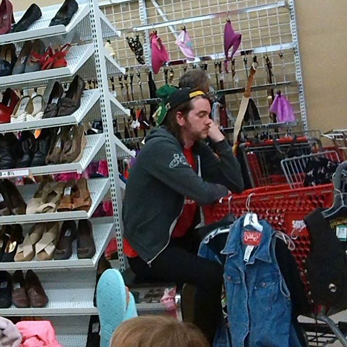 Hombres esperando que su mujer salda de las tiendas en el centro comercial 