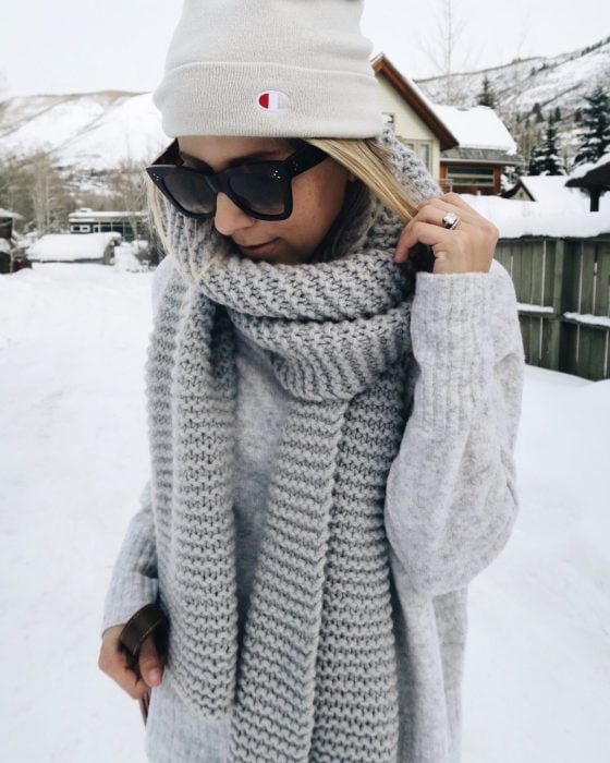 Chica usando una bufanda de color gris y un gorro blanco