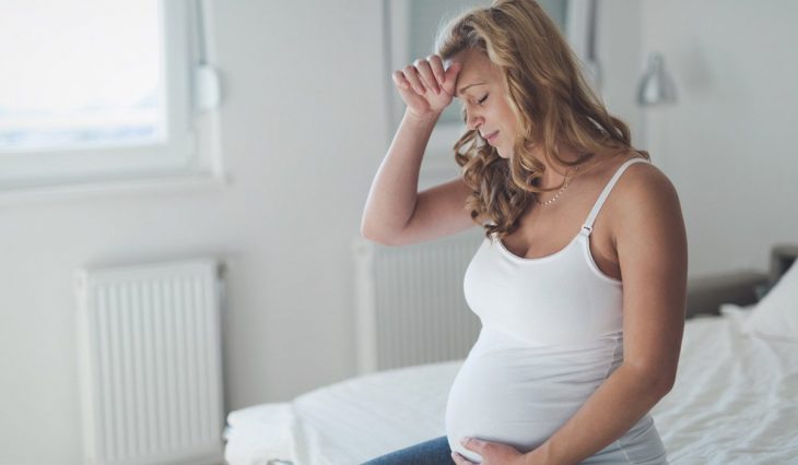 Mujer embarazada sujetando su cabeza