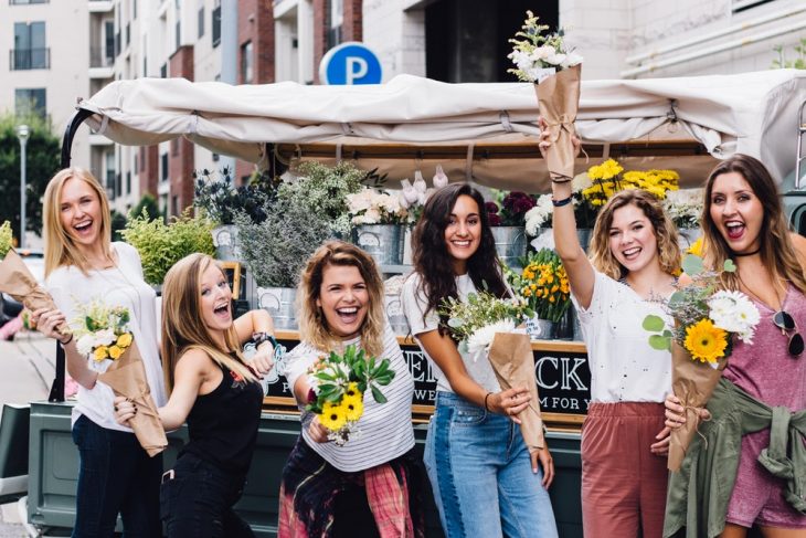 grupo de chicas felices cargando flores