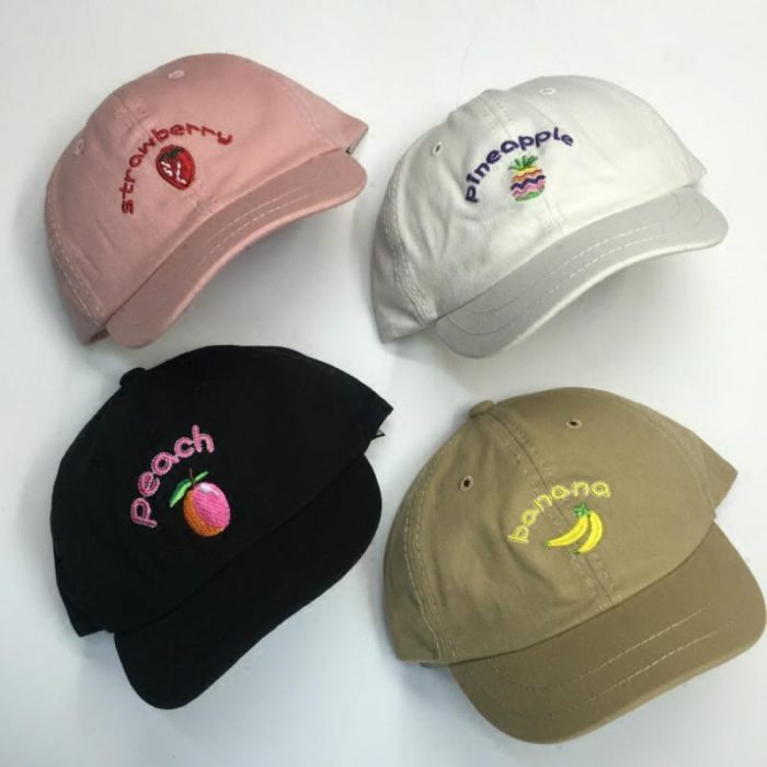 cuatro gorras de colores y frutas 