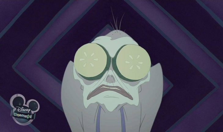 Yzma con una mascarilla y rodajas de pepino en los ojos