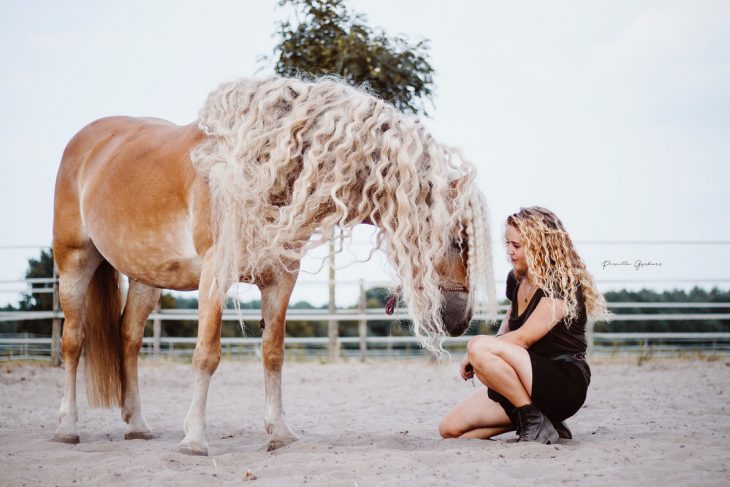 mujer rubia con cabello rizado y caballo 