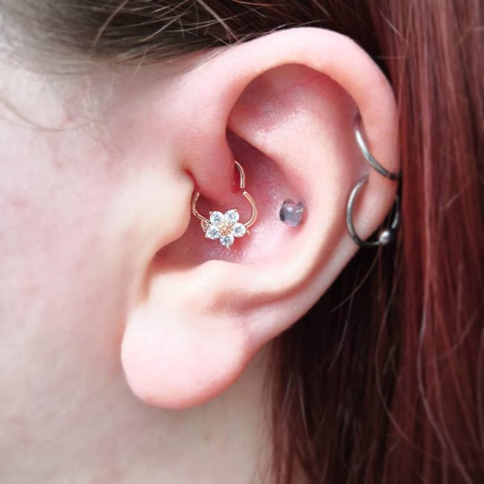 oreja de mujer con pearcings y aretes 