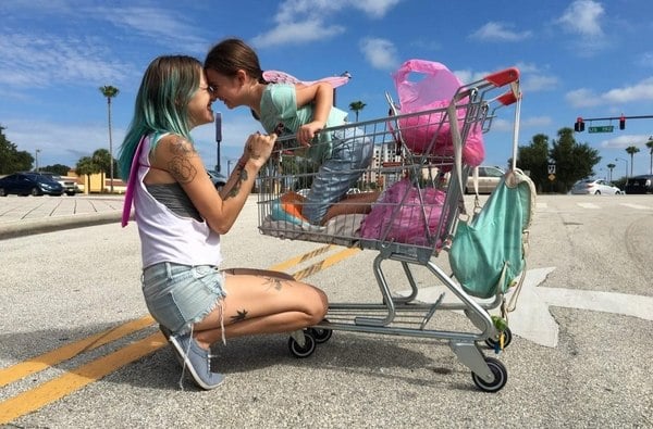 madre e hija jugando con carrito de supermercado
