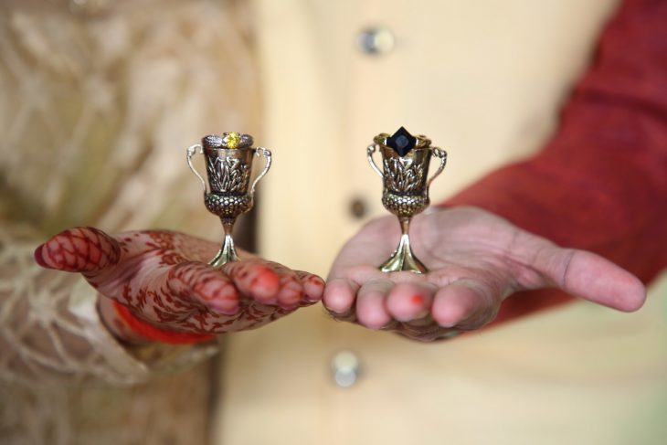 manos de hombre y mujer con trofeo pequeño 