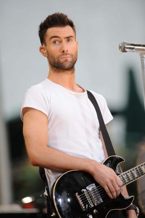 Adam Levine de Maroon 5, hombre con playera blanca tocando la guitarra