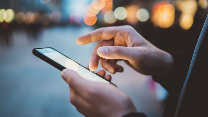 Manos de mujer sosteniendo un celular, aplicaciones de seguridad para celular