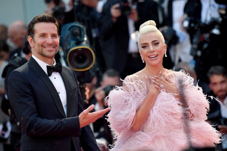 mujer bronceada con vestido rosa y hombre con smoking 