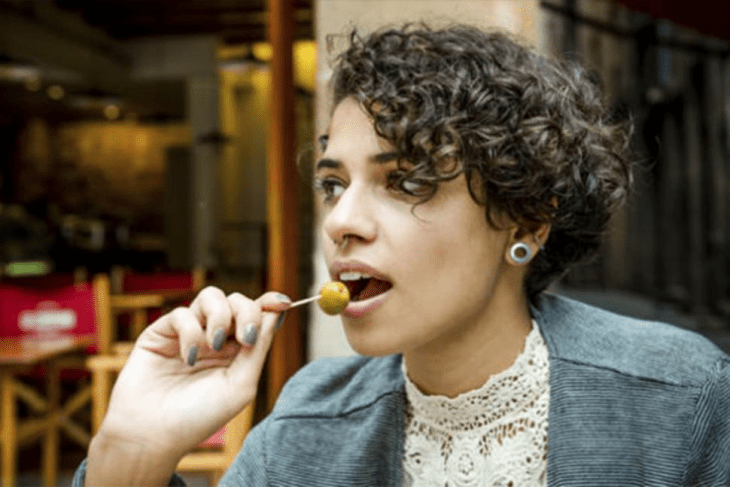 chica comiendo aceitunas verdes 